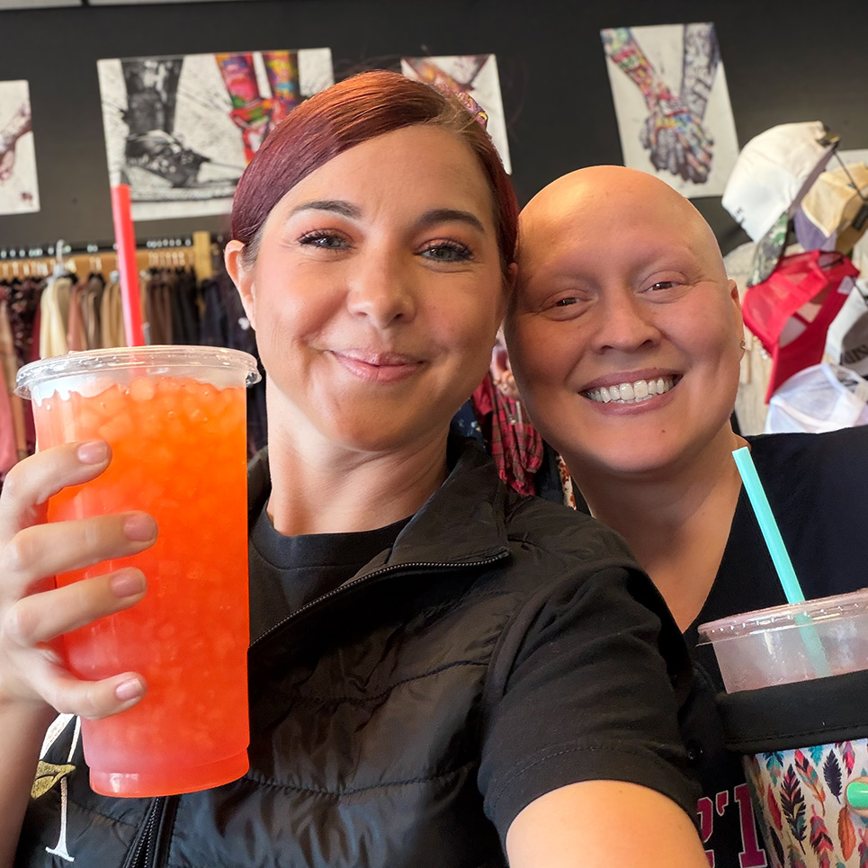 A Summit Senior Living team member poses for a selfie with a local businesses owner, each holding a tall, icy beverage.