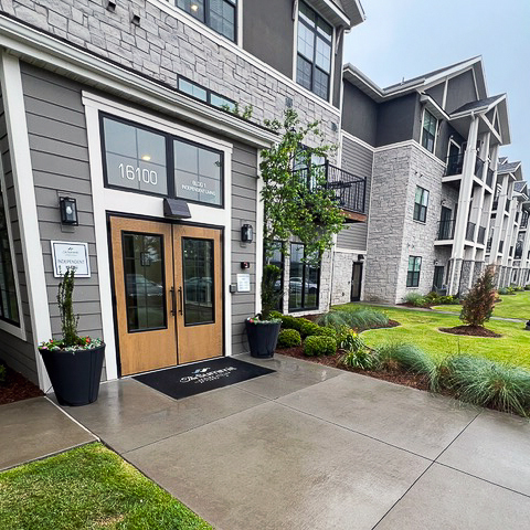 The exterior of The Summit Senior Living at Chenal Valley, showcasing freshly planted foliage.
